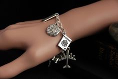 "A collection of silver plated travel and tourism themed charms have been dispersed around a shimmering silver plated bracelet chain in this handmade charm bracelet. This world traveler charm bracelet is then completed with a lobster clasp and a 1/2 inch of chain at the end for adjustable sizing. Charms in this bracelet include an airplane charm, passport charm, \"find joy in the journey\" charm, world charm, camera charm, \"bon voyage\" charm, suitcase charm, binoculars charm, and compass charm Nickel-free Silver Bracelets As Souvenir, Silver Nickel-free Bracelet Souvenir, Adjustable Silver Jewelry For Travel, Silver Metal Jewelry For Travel, Camera Charm, Find Joy In The Journey, Travel Bracelet, Handmade Charm Bracelets, Joy In The Journey