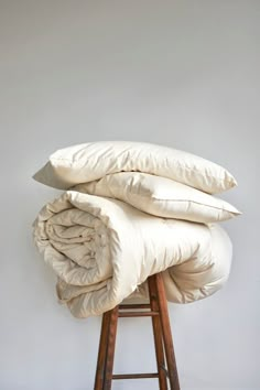 a stack of pillows sitting on top of a stool