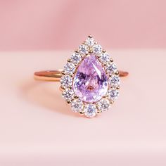 a pink diamond ring with white diamonds around it