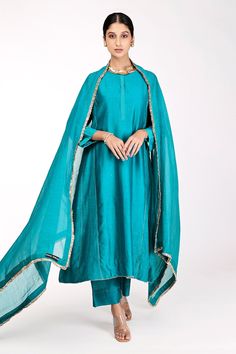 Blue-green chanderi kalidar kurta with mukaish hand and zari machine embroidery. Comes with pant and a dupatta.
Component: 3
Pattern: Embroidered
Type Of Work: Mukaish, Zari
Neckline: Round
Sleeve Type: Full
Fabric: Chanderi, Lining : Cotton
Color: Blue, Green
Other Details: 
Note : Necklace worn by the model is not for sale.
Occasion: Puja - Aza Fashions Eid Tussar Silk Salwar Kameez Straight Kurta, Designer Raw Silk Churidar In Straight Kurta Shape, Designer Raw Silk Churidar With Straight Kurta, Blue Tussar Silk Salwar Kameez With Traditional Drape, Raw Silk Churidar With Straight Kurta, Traditional Blue Tussar Silk Salwar Kameez, Tussar Silk Palazzo Set With Dabka On Straight Kurta, Blue Tussar Silk Bollywood Salwar Kameez, Designer Dabka Embroidered Tussar Silk Dupatta