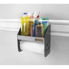 a shelf that has some bottles and other items in it on the wall next to a toilet paper dispenser