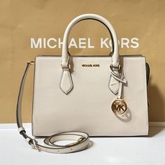 New With Tag Michael Kors Sheila Medium Satchel Shoulder Crossbody Bag Vegan Leather Light Cream 100% Authentic Retail: $558.00 Plus Tax **Please See The Measurement For The Size** No Dust Bag Michael Kors Logo At Front Gold Toned Hardware 1 Mk Charm Zip Top Closure Triple Compartment With Center Zip Custom Fabric Lining 1 Zipper Pocket 1 Slip-In Pocket 11"(Top) 12"(Bottom) (L) X 8.5"(H) X 4"(D) Straps: 4" Adjustable Strap: 20.25"-23.75" Very Clean, Smoke-Free And Pet-Free Environment