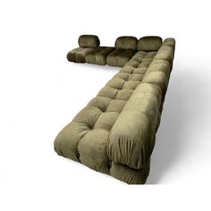 a very long couch that is made out of some kind of fabric and has four pillows on it