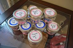 a glass table topped with lots of jars filled with candy and thank you written on them