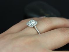 a woman's hand with a diamond ring on her finger and an engagement band