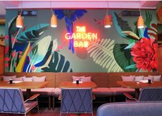 the garden bar is decorated with tropical flowers and palm leaves, along with neon lights