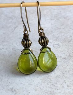 "olive green czech glass earrings boho earrings for women Olive green, Czech glass, flat teardrops are wire wrapped to round, corrugated antiqued brass beads. Hook ear wires are antiqued brass. Length of earrings from top of ear wires is 1 5/8\". Glass teardrops measure 12x16mm, 5/8\" long. You can enter my shop here: gypsydangles.etsy.com" Green Czech Glass Teardrop Jewelry, Green Teardrop Czech Glass Jewelry, Green Teardrop Glass Jewelry, Czech Glass Teardrop Earrings With Ear Wire, Green Teardrop Drop Earrings For Jewelry Making, Green Teardrop Drop Earrings Nickel Free, Green Teardrop Brass Jewelry, Green Nickel-free Teardrop Drop Earrings, Green Nickel-free Teardrop Earrings