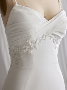 the back of a white wedding dress on a mannequin