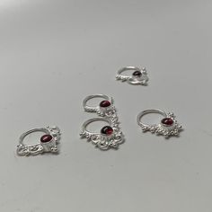 These are soooooo pretty. Made is 925 sterling silver with tribal details, set with a deep red garnet stone. The rings are all 1cm (.40”) in diameter. The wire is 18 gauge.Stones shine light through them since the back is open. Hard to see this when they are lying flat.One of the images contains numbers to specify which you would like from the drop down menu. Spiritual Silver Rings With Garnet, Spiritual Silver Garnet Rings, Gothic Silver Garnet Jewelry, Silver Garnet Rings With Spiritual Style, Silver Spiritual Garnet Rings, Garnet Stone, Nose Ring Stud, Red Garnet, Tragus