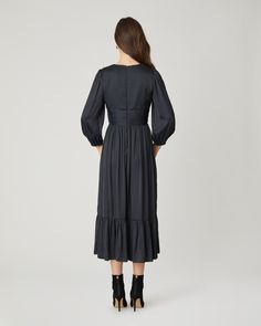 Gorgeous black satin midi dress. This style features a v-neckline with a fitted bodice, decorative buttons at the center front, shirring at the shoulder and waistband, ¾ length balloon sleeves with encased elastic at the openings, and a shirred full midi skirt with bottom ruffle flounce. Bodice lined. Sleeves and skirt unlined. Hidden back zipper. 100% Polyester. Dry clean or hand wash. Color: Jet Elegant V-neck Midi Dress With Elastic Sleeves, Elegant V-neck Dress With Smocked Bodice, Spring Midi Dress With Gathered Waist For Date Night, Spring V-neck Puff Sleeve Dress With Ruched Bodice, Chic Empire Waist Midi Dress With Ruched Bodice, Chic Midi Dress With Ruched Bodice And Empire Waist, Elegant Midi Dress With Smocked Bodice, Pleated Sleeve Midi Dress For Brunch, Midi-length Dress With Pleated Waist For Brunch