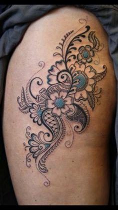 a woman's thigh with an intricate tattoo design on the side of her leg