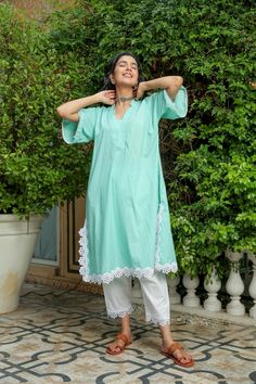 Dusty jade kurtapant set is perfect for a festive season or a day out .Cotton cambric fabric makes it perfect for summer weather. Front v-neckline kurta with lace detail bell sleeves give a classic look. Product has no lining. Pant has two side pockets, back elasted waistband and lace on the hem. Cold wash and Dry clean only.Type of Work: Solid Fit: Loose Model Height: 5'7 Measurements: Kurta-36.5" Pant- 34" SKU#: 11702071GR Disclaimer: There may be slight difference in actual product color comp Bohemian Cotton V-neck Sets, Green Cotton V-neck Set, Festive Cotton V-neck Kurta, Festive V-neck Kurta For Spring, Spring Festive V-neck Kurta, Festive Spring V-neck Kurta, Cotton V-neck Kurta With Chikankari Embroidery, Festive Cotton V-neck Kaftan, V-neck Kurta With Chikankari Embroidery For Spring