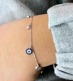 "Beautiful Sterling Silver evil eye bracelet with cross! looks great with other pieces. perfect for everyday wear and as a gift. * bracelet is 7.5 + 1\" extender * evil eye charm is 7 mm  * cubic Zirconia is 3mm -------- Evil Eye The evil eye, known as \"mati\" (μάτι) in Greek culture, is a curse thought to be given by a malicious glare that can cause bad luck or loss. People can knowingly wish negative thoughts on you, but the power of the eye is that some people unknowingly and innocently cast Pure Silver Bracelet For Women, Dainty Sterling Silver Adjustable Evil Eye Bracelet, Dainty Sterling Silver Evil Eye Bracelet, Silver Sterling Silver Evil Eye Bracelet Dainty Style, Silver Sterling Silver Evil Eye Bracelet, Dainty Style, Silver Chain Bracelet With Evil Eye Detail, Dainty Silver Sterling Evil Eye Bracelet, Sterling Silver Evil Eye Bracelet, Evil Eye Jewelry Bracelet