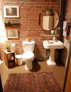 a bathroom with brick walls and a rug on the floor