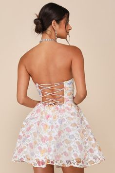 Get ready to charm your way through the evening in the Lulus Deeply Adorable White Burnout Floral Strapless Mini Dress! Lightweight woven fabric, with a burnout floral design, shapes a strapless bustier-style bodice that has a sweetheart neckline (with hidden no-slip strips), seamed cups, and ruffled trim. At the back, a flirty lace-up panel creates a sultry effect. Paneled bodice has supportive boning and a Basque waist. Flaring skirt has a hidden layer of tulle for volume, ending at a mini hem Strapless Floral Print Dresses For Prom Season, Strapless Tie Back Prom Dresses, Strapless Floral Print Dress With Fitted Bodice, Summer Dress With Boned Bodice For Homecoming, Lace Dress With Tie Back And Sweetheart Neckline, Backless Lace Dress For Garden Party, Summer Homecoming Dress With Boned Bodice, Spring Homecoming Dresses With Boned Bodice, Evening Strapless Dress With Sweetheart Neckline And Floral Print