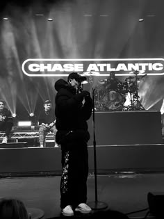 a man standing on top of a stage holding a microphone in front of his face