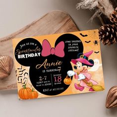 a minnie mouse birthday party with pumpkins and pineconi on the table next to it