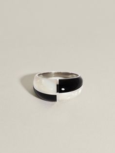 A new iteration of our beloved Form Ring incorporates inky black Onyx and iridescent white Mother of Pearl, inlaid in quadrants and framed in sterling silver or 14k gold. Billowing yet structured, these pieces take cues from avant proportion, exploring how graceful softness can be found within precise form.Measures approximately 10 mm in the front, tapering to 3 mm in the back. Solid 14k gold or sterling silver ring with a nice weight to it. Not quite sure of your ring size? To get the best fit Modern Black Enamel Ring Jewelry, Modern Black Enamel Ring, Modern Black Enamel Jewelry, Modern Black Enamel Open Ring Jewelry, Modern Sterling Silver Jewelry With Black Enamel, Modernist Open Ring Jewelry With Polished Finish, Modern Onyx Open Ring Jewelry, Elegant Black Rings With Inlay, White Elegant Jewelry With Inlay