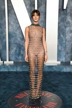 an image of a woman in a sheer dress at the vanity magazine cover party on blue carpet