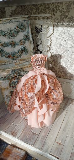 a dress made out of fabric sitting on top of a wooden table next to an old chest