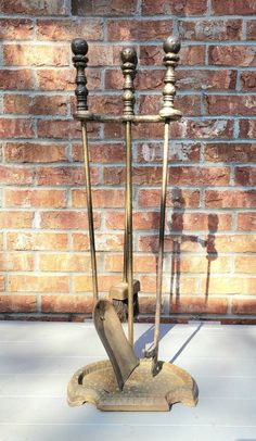 a candle holder with three candles on it in front of a brick wall and white table