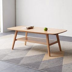 a wooden table sitting on top of a carpeted floor next to a white wall