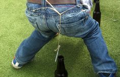 a man is tied up to a chair with two bottles in front of his back