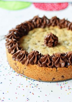 a cake with chocolate frosting and sprinkles sitting on top of a table