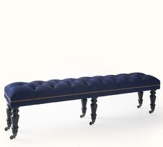 an upholstered bench with wheels on the legs