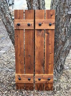 a wooden door sitting next to a tree