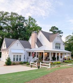 a large white house sitting on top of a lush green field