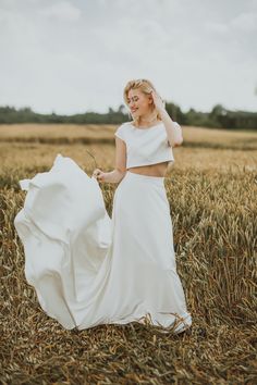 a woman in a white dress standing in a field