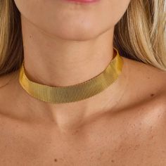 The Gold-Plated Mesh Choker is a piece that blends modern style with a classic touch. Crafted from smooth mesh chain, it offers a sleek texture and an elegant design. The choker's structure is made from noble metal and is gold-plated, providing a luxurious and radiant finish. With a length of 32 cm, this choker is a versatile option to elegantly highlight the neck. The minimalist design of the smooth mesh adds a contemporary touch, while the gold plating lends a classic charm to the piece. This choker is perfect for wearing alone, creating an elegant focal point in your outfit, or layered with other necklaces for a customized style. Its versatility allows it to be worn on various occasions, adding a touch of glamour and sophistication to any look. In summary, the Gold-Plated Mesh Choker is Metal Snake Chain Choker With Adjustable Chain, Adjustable Metal Snake Chain Choker, Metal Snake Chain Clavicle Choker, Elegant Gold Snake Chain Choker, Metal Snake Chain Choker, Party Snake Chain Metal Choker, Party Metal Snake Chain Choker, Metal Chainmail Necklace For Party, Party Chainmail Metal Necklace