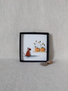 an orange cat sitting on top of a table next to a coin