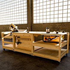 a workbench made out of wood with tools on it and windows in the background