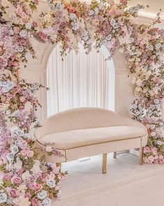 a white couch sitting under a flower covered arch