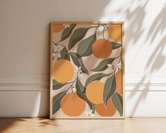 an orange print hangs on the wall next to a potted plant