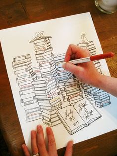 a person is drawing books on a piece of paper