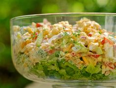 a glass bowl filled with salad sitting on top of a table