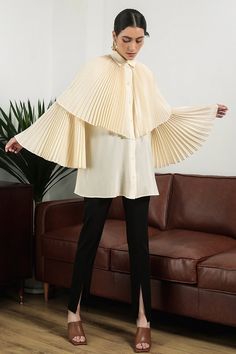 The blouse is impressive with a pleated cape and sleeves design symbolizing the wings that bring freedom in fashion. Special silk material is used for creating a soft look and bringing a relaxed feeling to the wearer. Note:*Processing time takes 7-10 working days (including 3-5 working days for manufacturing and NOT including shipping time)**Backorder Definition- The product is low in stock and in case the customer purchased successfully after out of stock, the order will need time to restock.- Harsh Winter Outfits, Oversized Elegant Cape For Spring, Elegant Cape Top For Spring, Elegant Spring Cape Top, Chic Long Sleeve Spring Cape, Elegant Oversized Long Sleeve Cape, Chic Capelet With Cape Sleeves For Work, Cape Designs, Mean Blvd