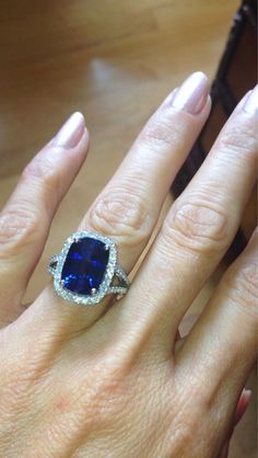 a woman's hand with a ring on it and a blue stone in the middle