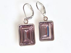 Handset emerald cut Swarovski jewel into silver-plated dangles. The shade is called light amethyst which is a very pale lavender hue. Each hangs on matching lever back ear wires for a glamorous red carpet look. The total length of the earrings is a little less than 1.5" long. Perfect for a special occasion or everyday bling. The third picture is for sizing purposes and is in a darker shade. Copyright ©, all rights reserved. LoveYourBling® is an authorized SWAROVSKI® Crystals Branding Partner. Luxury Faceted Purple Earrings, Pale Lavender, Glamorous Look, Red Carpet Look, Light Amethyst, Dark Shades, Amethyst Crystal, Emerald Cut, Ear Wires