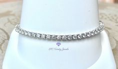 This Moissanite tennis bracelet is gorgeous and eye-catching. This glamorous bracelet embellishes the wrist with 53 (3mm) super sparkly D colorless Moissanites. I offer the bracelet in 6.2 inches long or 7 inches long, with a box clasp & safety. The bracelet is rhodium plated over 925 sterling silver. This bracelet would look amazing with my 3mm D colorless half eternity band. To view the half eternity band copy & paste this link:  https://www.etsy.com/listing/1063013651/3mm-d-colorless-moissanite-rhodium?click_key=1f493f1ce10b155dc792b8e2fb24b16dcbe48d99%3A1063013651&click_sum=fd251225&ref=shop_home_active_13&frs=1&crt=1&sts=1 This bracelet can also be made in 10k or 14k gold. Please message me for the price. *EACH MOISSANITE HAS BEEN TESTED FOR AUTHENTICITY The rhodium plating helps ster Outfit Styles, Jewelry Accessories Ideas, Half Eternity Band, Wedding Jewelry Bracelets, Box Clasp, Accessories Ideas, Silver Box, Dainty Bracelets, Fancy Jewelry