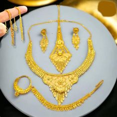 "Transform your wedding day into a breathtaking spectacle with our exquisite 22k gold-plated Indian bridal jewelry set. This stunning ensemble includes a necklace, matching earrings, a delicate nose ring, and a support chain, all meticulously designed to radiate timeless elegance. Crafted to resemble the richness of 1-gram gold Indian jewelry, this collection is the epitome of opulence without the hefty price tag. Make a statement on your special day with the allure of traditional Indian design Gold Bridal Sets Gift, Gold Round Bridal Sets As Gift, Gold Plated Bridal Sets Gift, Gold Plated Round Bridal Sets As Gift, Gold Hand Set Jewelry Sets For Anniversary, Gold Plated Bridal Set For Anniversary, Gold Plated Jewelry Sets For Marriage, Gold Plated Bridal Sets For Festivals, Yellow Gold Plated Jewelry For Marriage