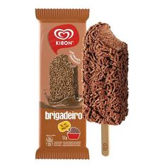 a chocolate lollipop is on a stick with the package in front of it