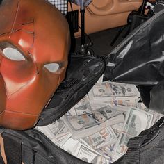 a bag filled with money and a mask on top of it