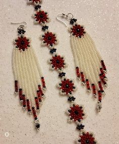 two pairs of beaded earrings with red, white and black beads hanging from them