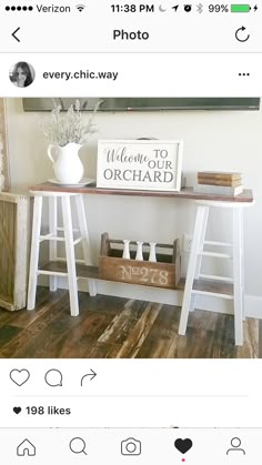 a white table with two wooden ladders on it and a sign that says welcome to orchard