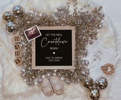 a baby announcement surrounded by silver and white items, such as shoes, bracelets, and t - shirts