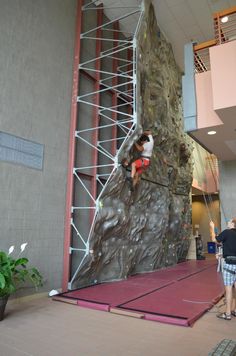 a man climbing up the side of a rock wall